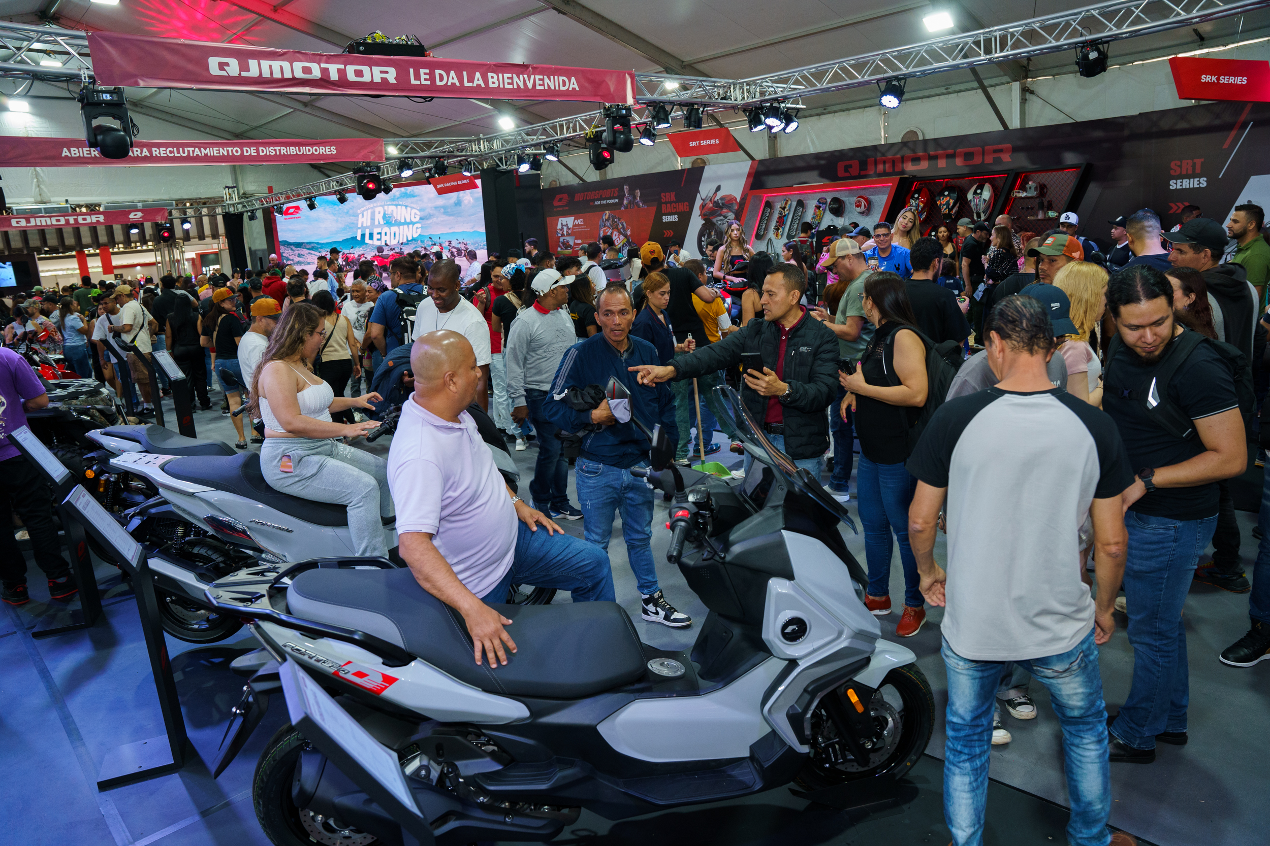 QJ Motor stand at Feria 2 Ruedas Medellín with visitors browsing the motorcycle lineup